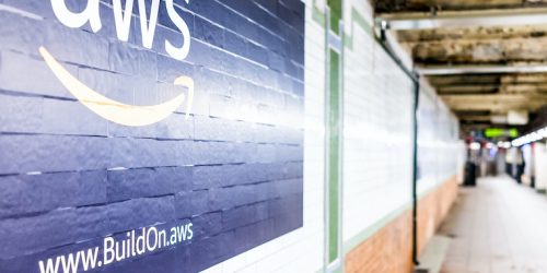 New York City: Amazon Web Services AWS advertisement ad sign closeup in underground transit platform in NYC Subway Station, wall tiled, arrow, side