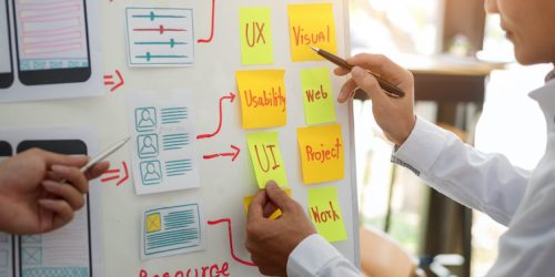 UX designer creative group working about planing mobile application project with sticky notes. User experience concept.