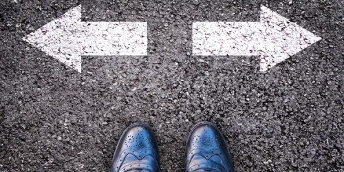 Feet and two arrows painted on an alphalt road